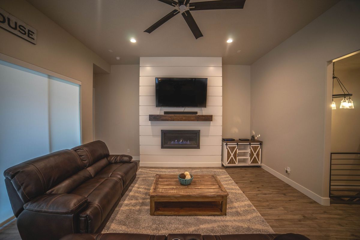A living room with a couch , coffee table , fireplace and television.