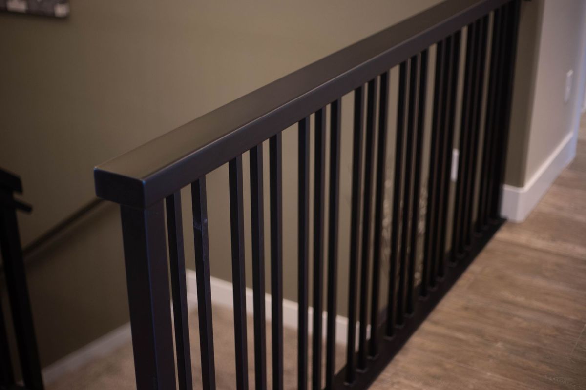 A close up of a black railing on a staircase.