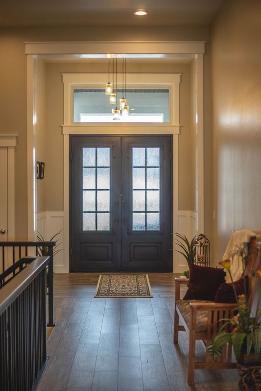 A hallway in a house with a black door and a wooden bench.