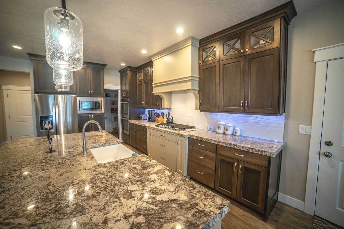 A kitchen with granite counter tops and stainless steel appliances.
