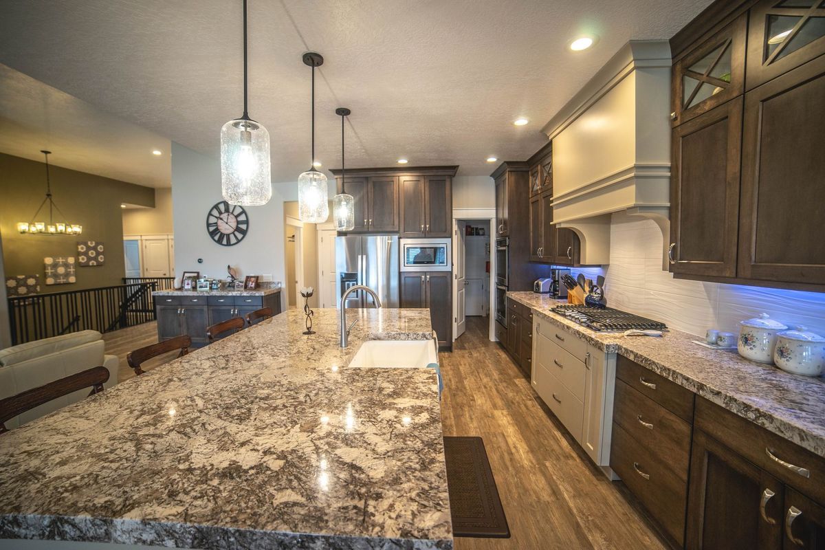 A kitchen with a large island and granite counter tops.