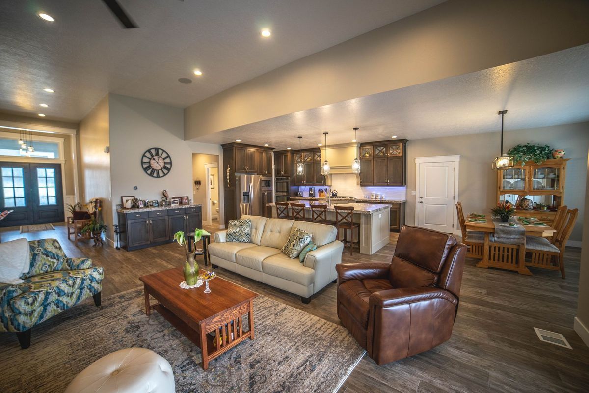 A living room with a couch , chair , coffee table , and kitchen.