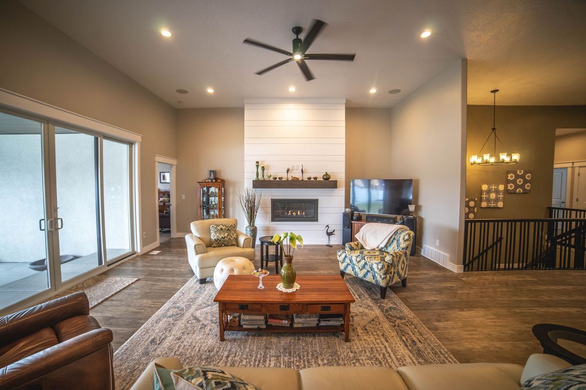 A living room filled with furniture and a fireplace with a ceiling fan.