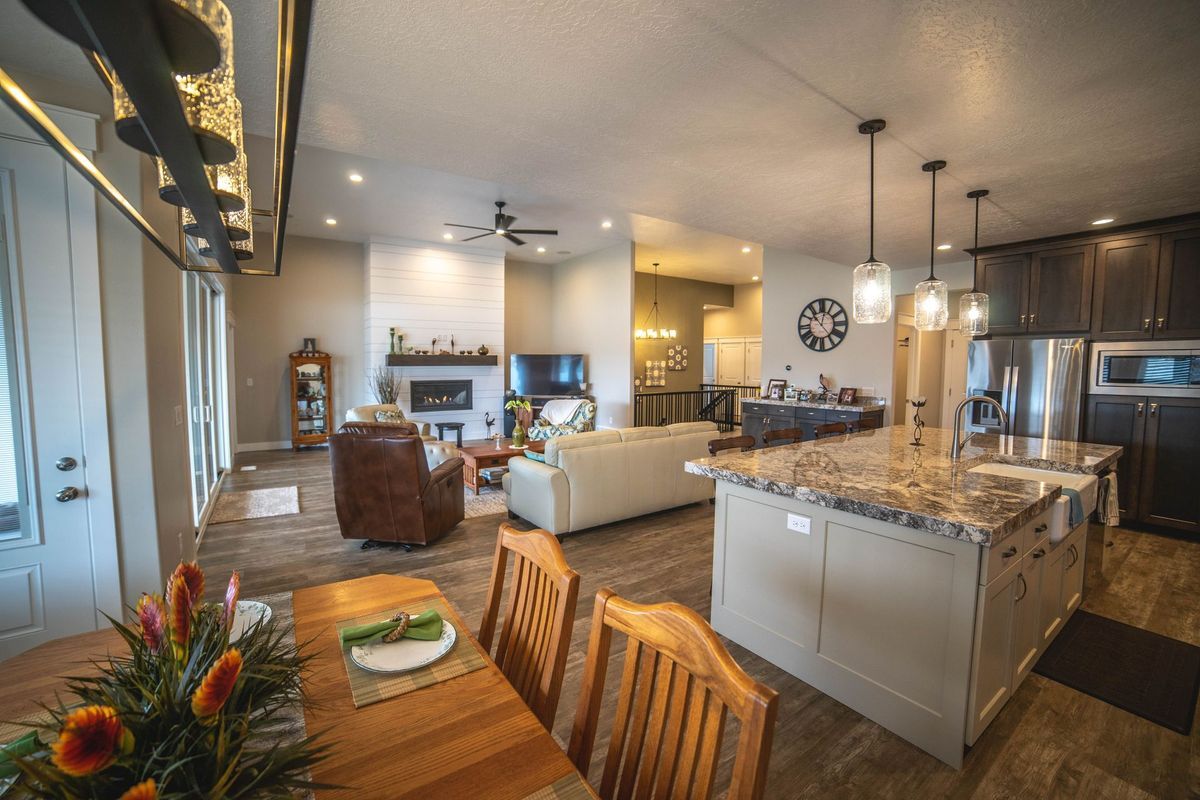 A living room with a dining table and chairs and a kitchen.