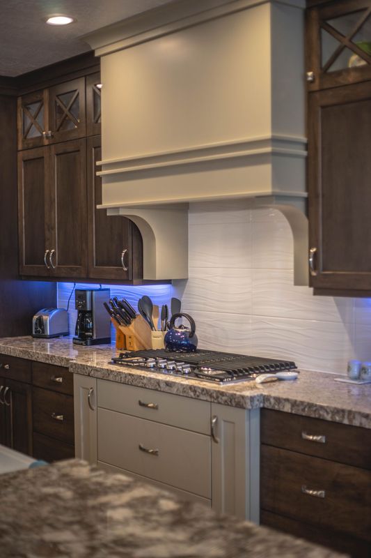 A kitchen with a stove top oven and a hood above it.