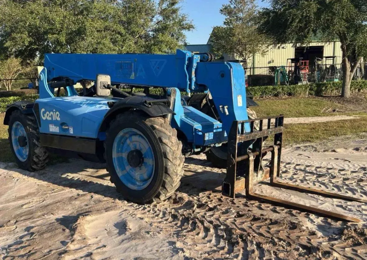 Blue Genie telehandler forklift on a sandy surface, outdoors.