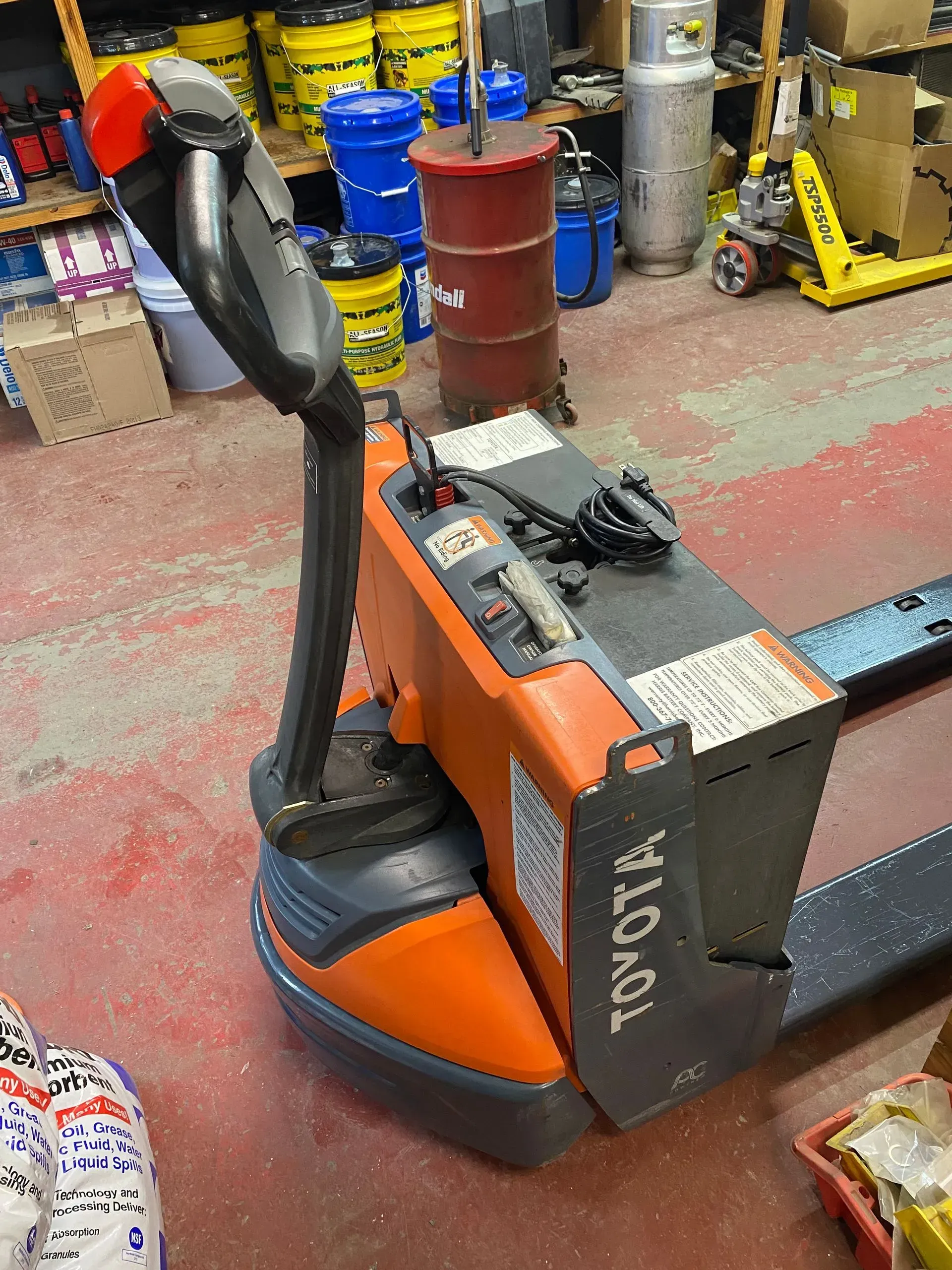Orange Toyota pallet jack in a warehouse setting.