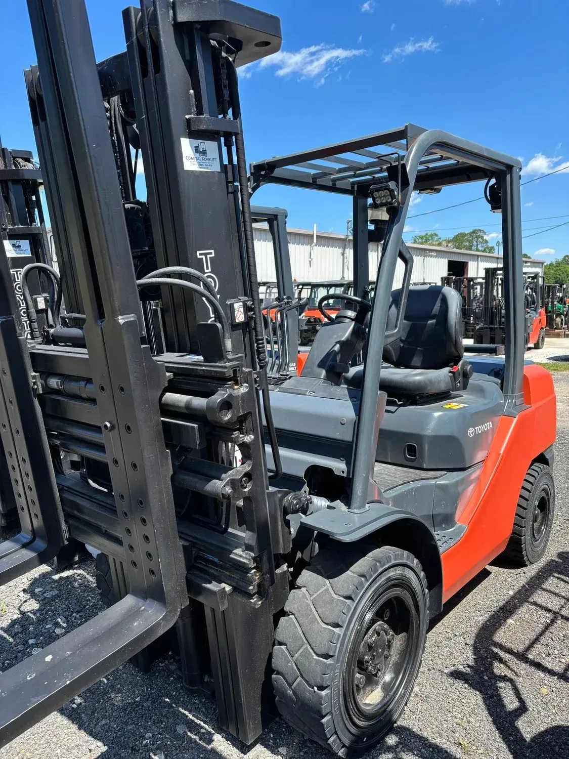 Orange and gray forklift on an outdoor lot.