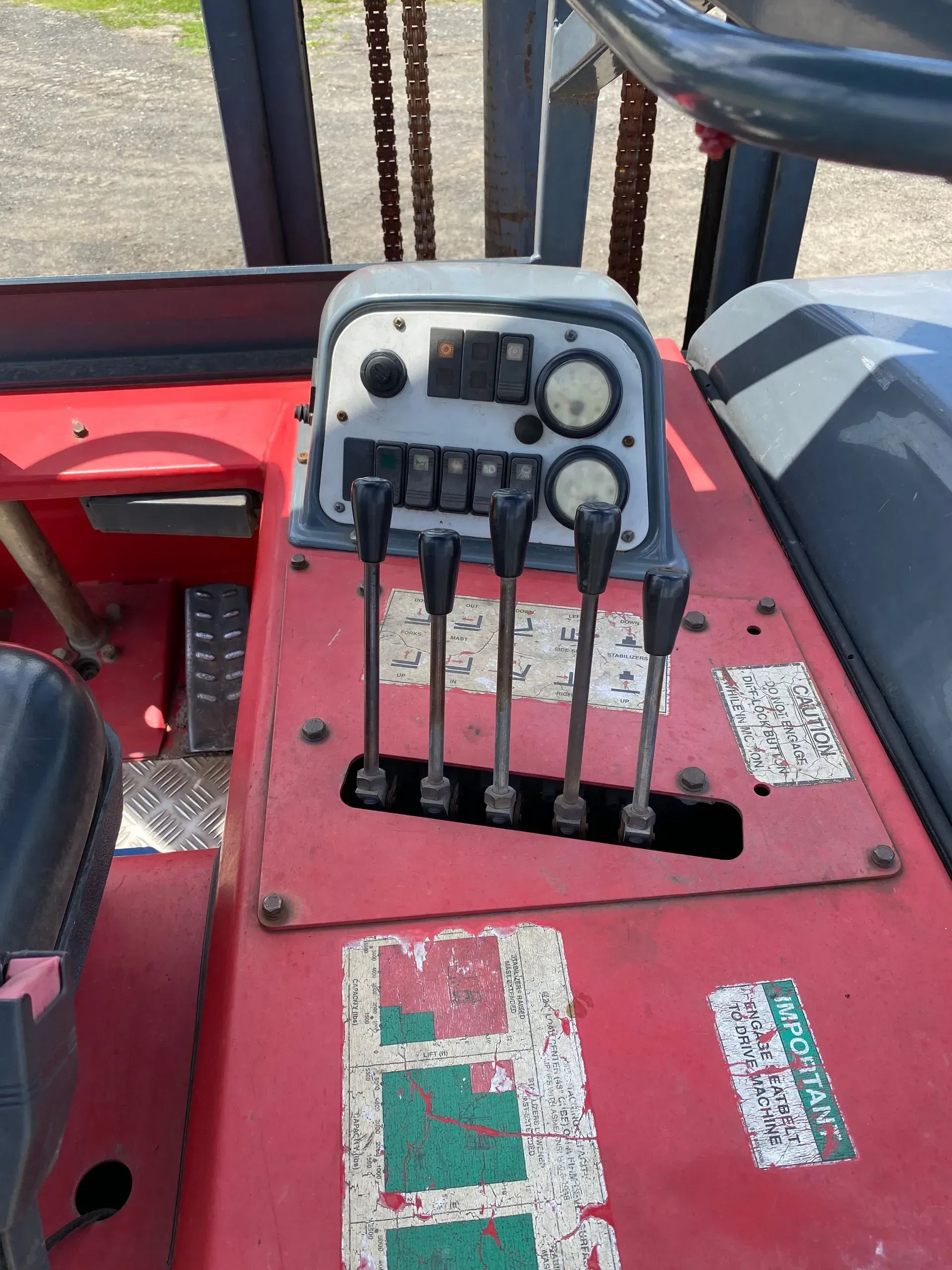 Interior of a red forklift cab. Controls include levers, gauges, and switches.