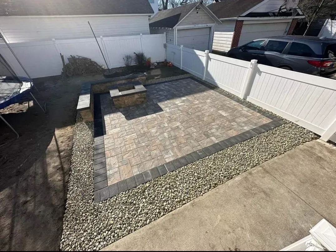 A backyard with a white fence and a patio
