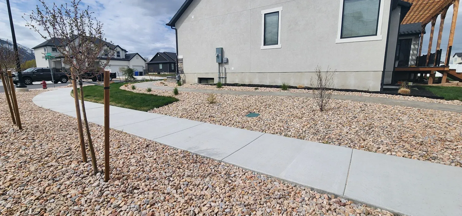 A house with a sidewalk and gravel in front of it.