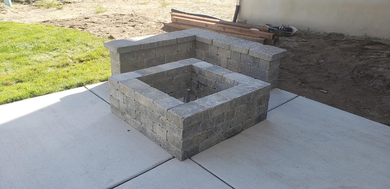 A fire pit is sitting on top of a concrete patio.