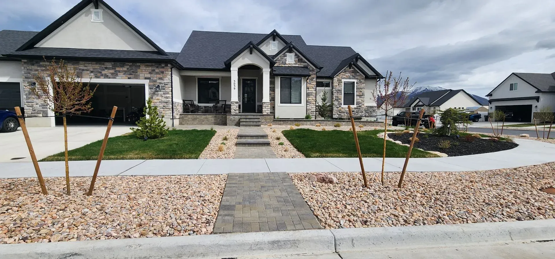 A large house with a lush green lawn and a walkway in front of it.