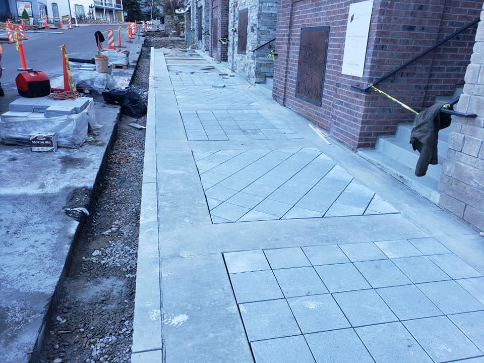 A sidewalk is being built in front of a brick building