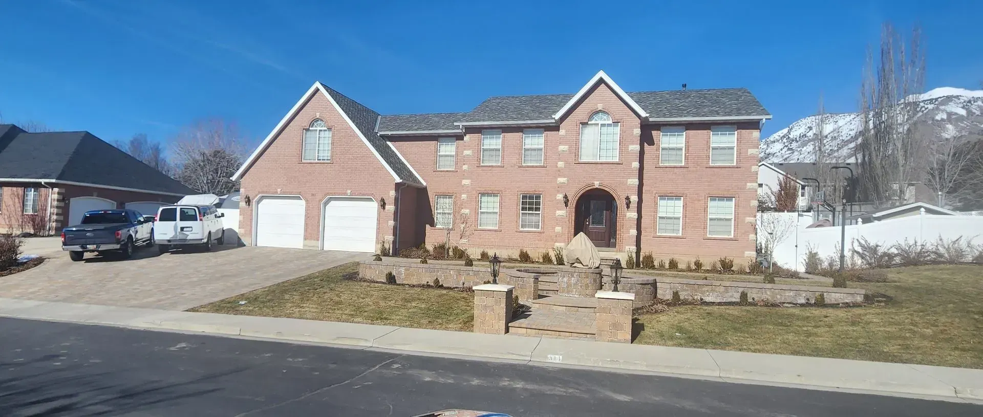 A large brick house with a car parked in front of it