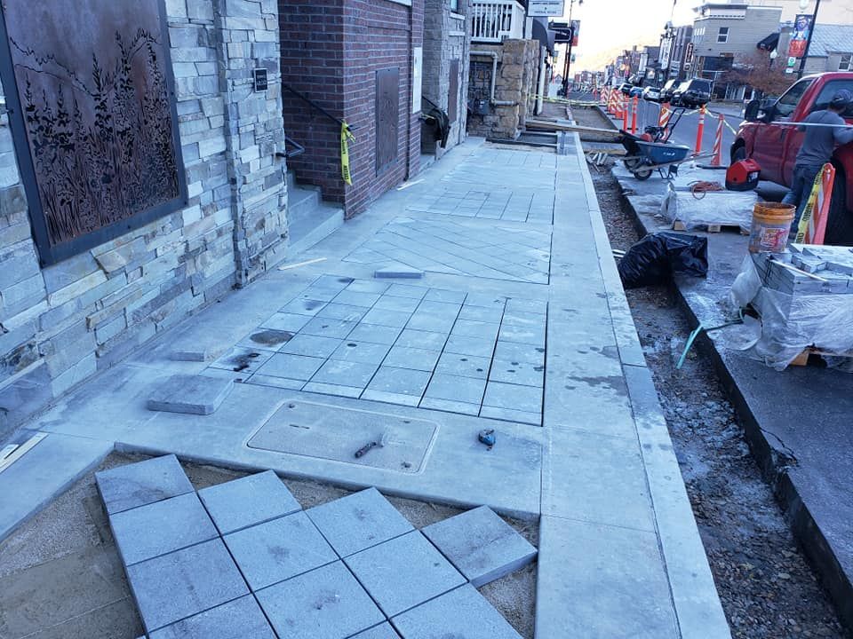 A sidewalk is being built on the side of a building.
