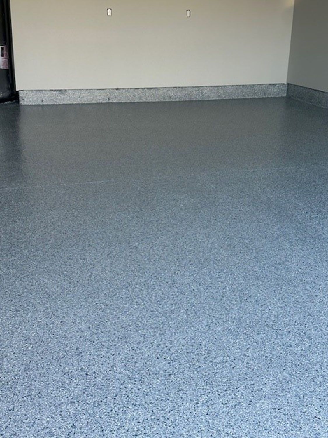 an empty room with a gray concrete floor and white walls