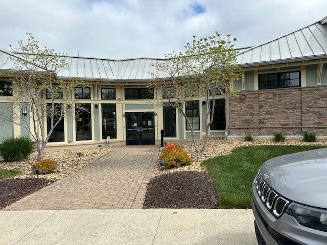 A jeep is parked in front of a large building