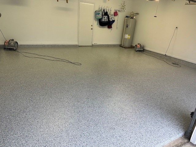 an empty room with a gray concrete floor and white walls