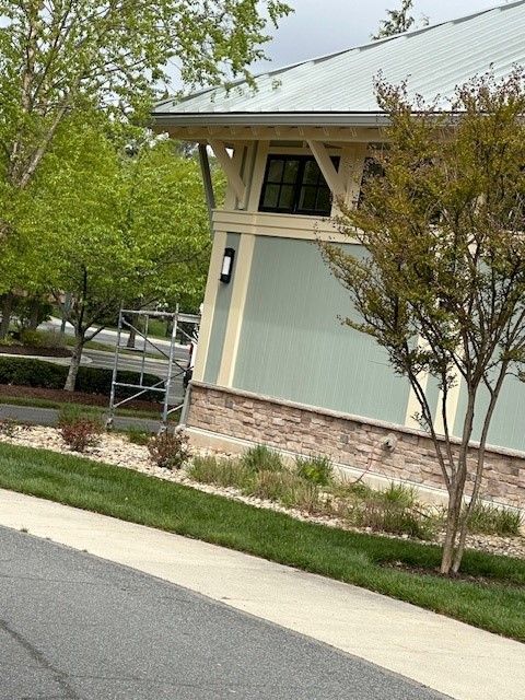 A house with a metal roof is next to a sidewalk