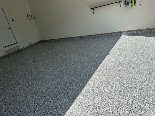 an empty room with a gray concrete floor and white walls
