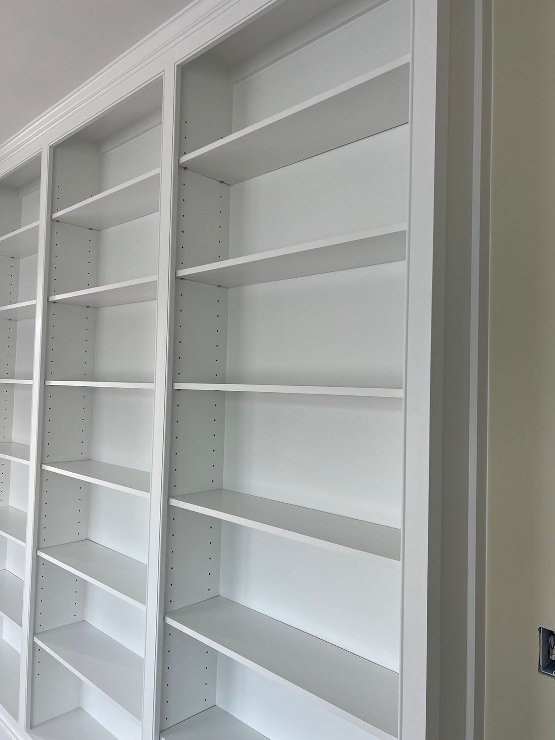 a row of empty white shelves in a room