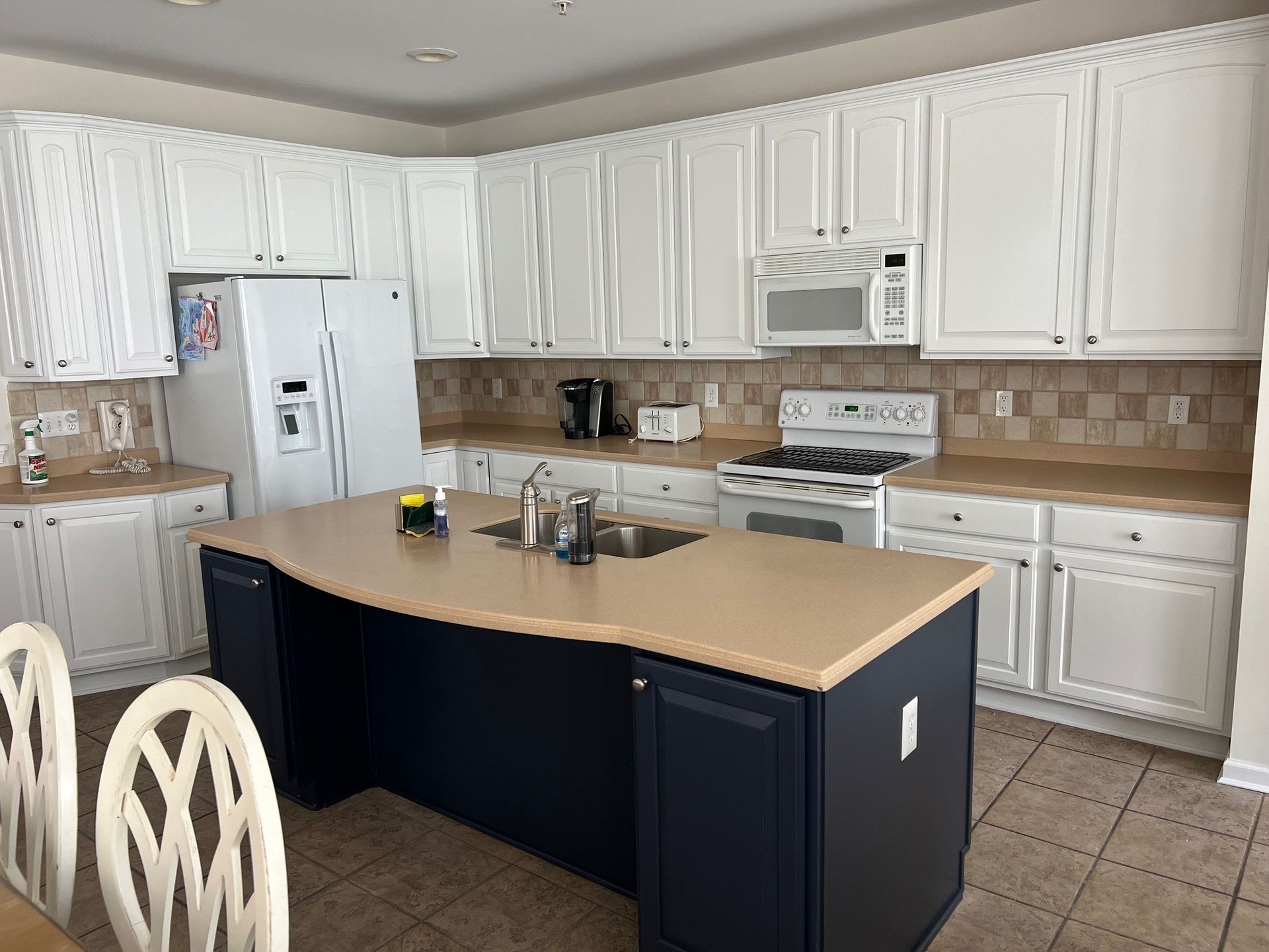 a kitchen with white cabinets and a large island in the middle