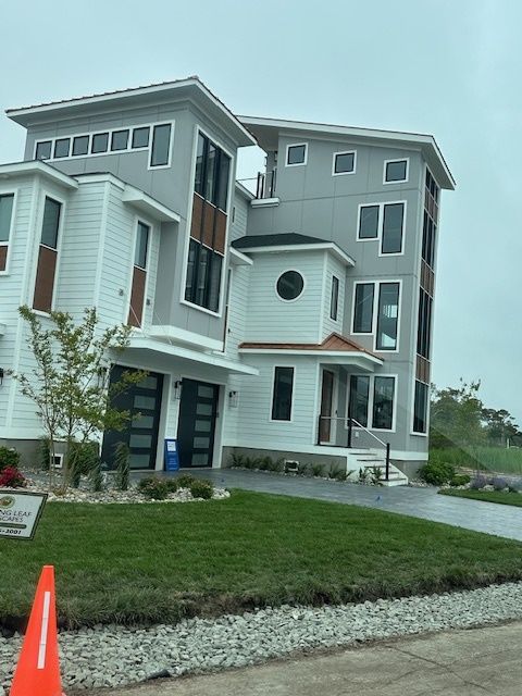 A large gray and white house with a round window