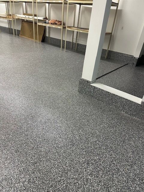 A room with a gray floor and shelves in it