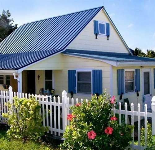A house with blue shutters and a white picket fence