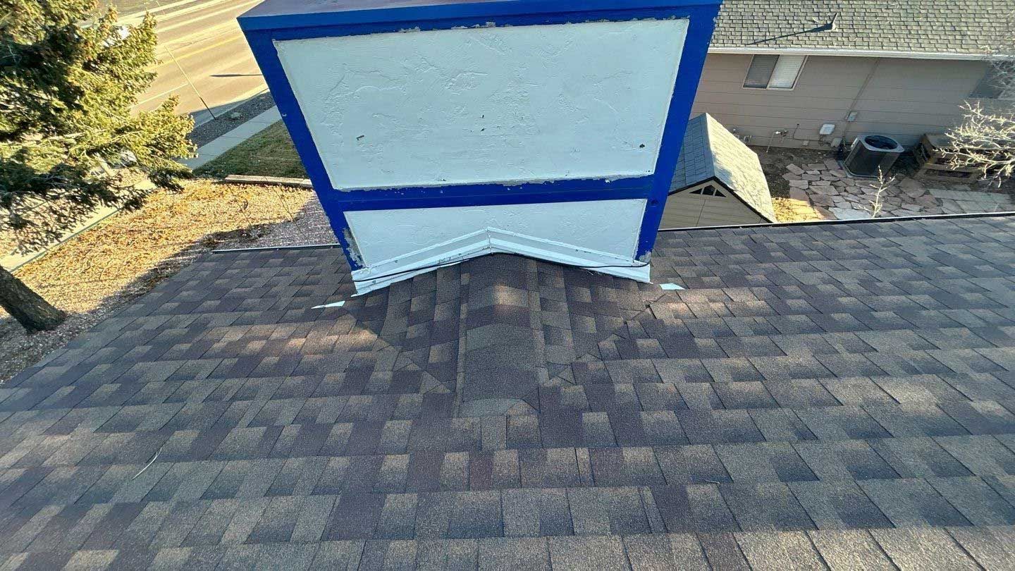 A blue and white chimney is sitting on top of a roof.