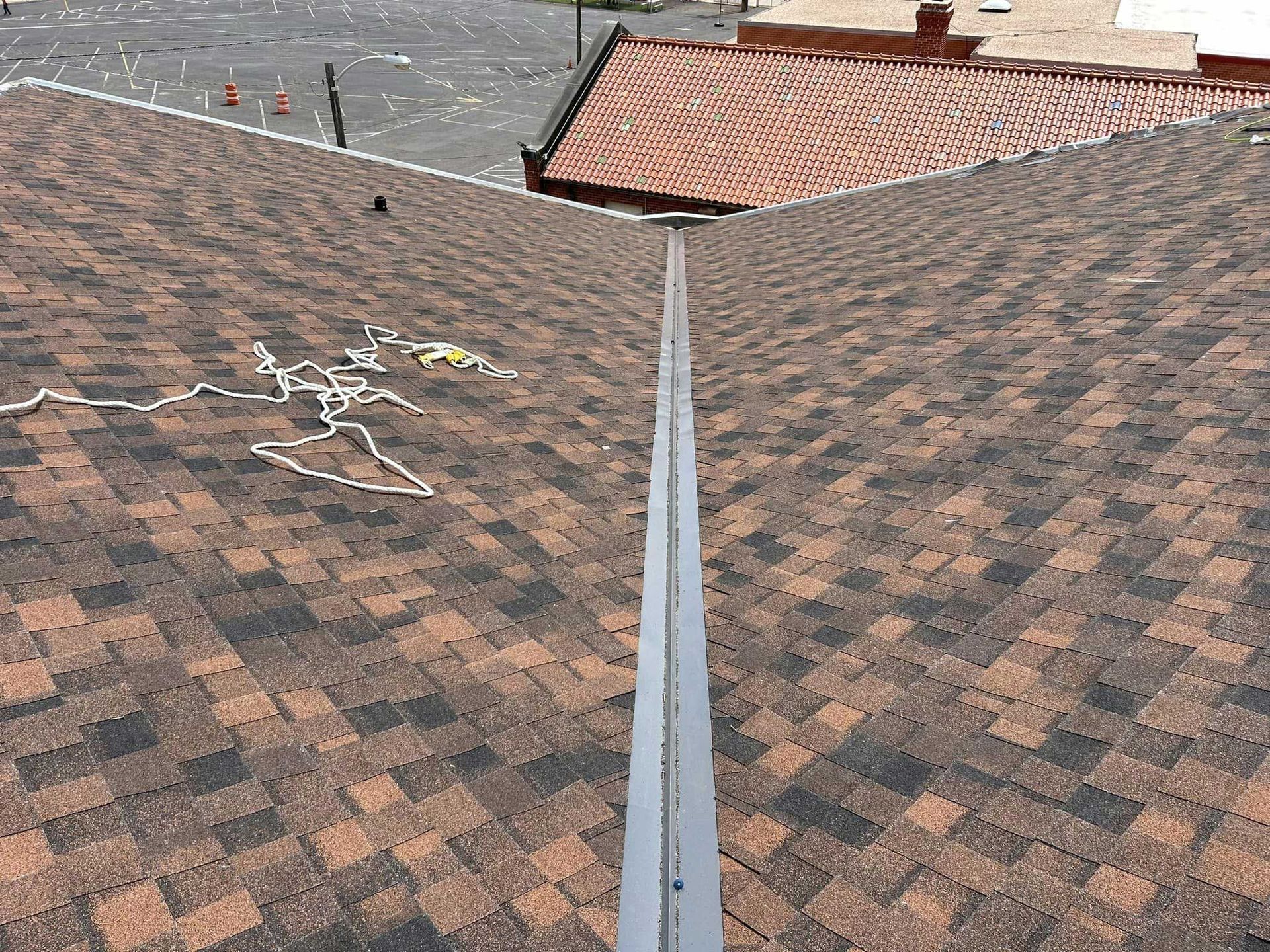 A close up of a roof with shingles and a gutter.