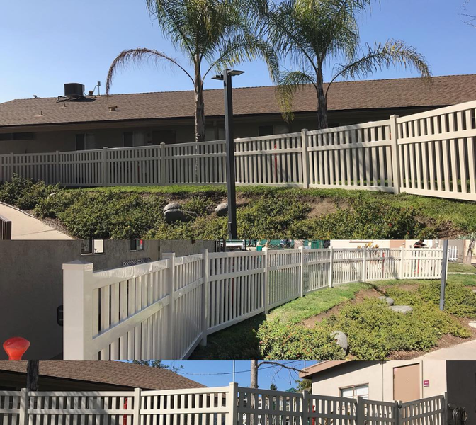 A white fence surrounds a house with palm trees in the background