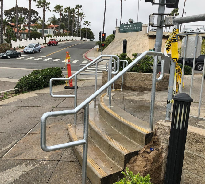 A staircase with a metal railing on the sidewalk
