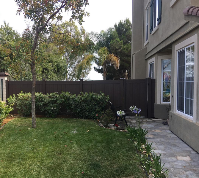 The backyard of a house with a fence and a patio