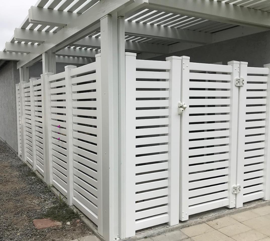 A white fence with a pergola attached to it.