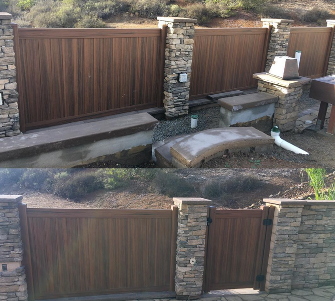 A wooden gate with a stone wall behind it