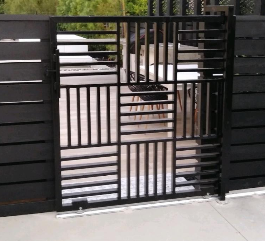 A black gate is open to a patio area