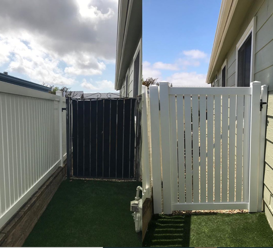 A white fence with a black gate between two buildings