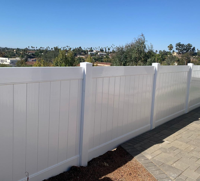 A white fence with a blue sky in the background
