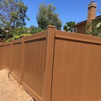 A wooden fence is sitting in front of a house.