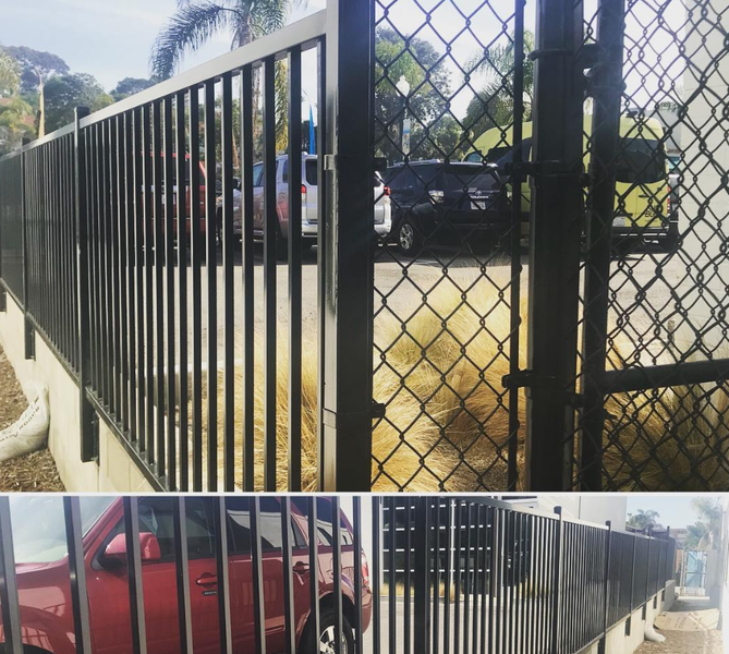 A chain link fence with a red car parked behind it.