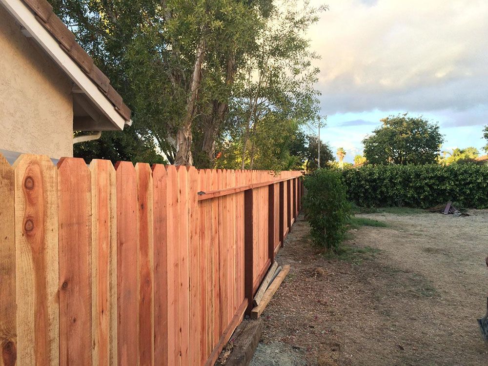 A wooden fence is being built in front of a house.