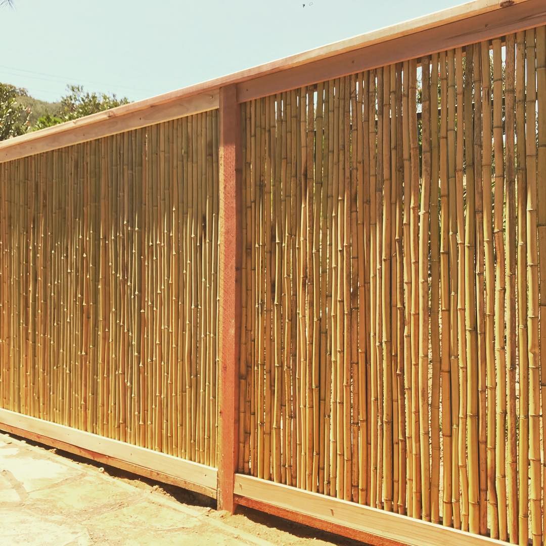 A close up of a bamboo fence with a wooden frame.