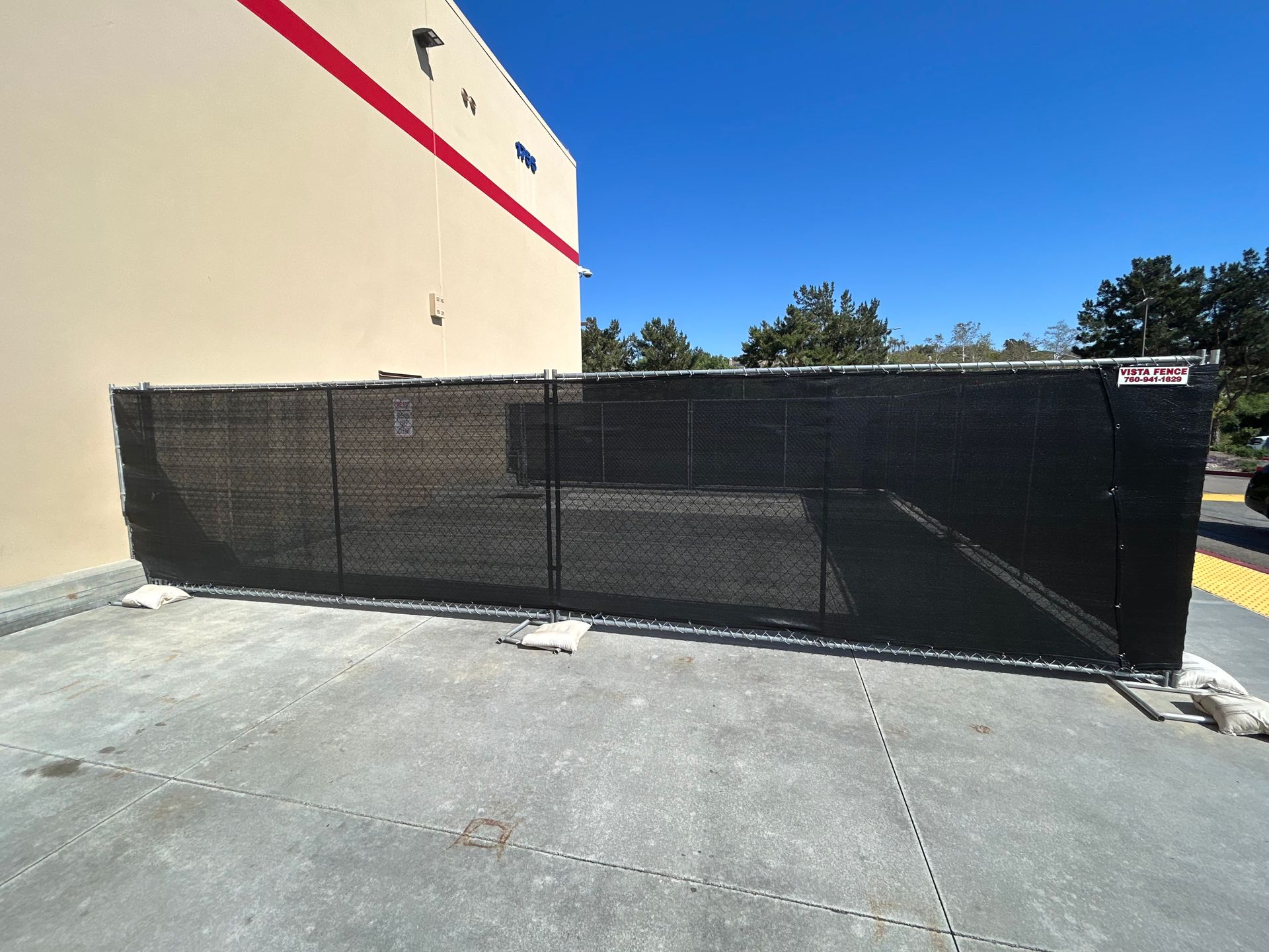 A large black fence is in front of a building.