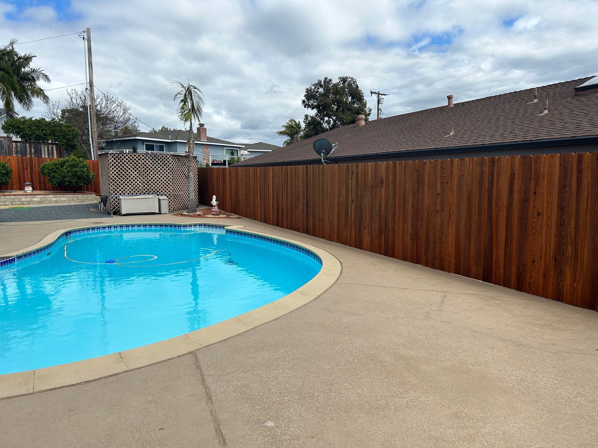 A large swimming pool with a wooden fence around it.