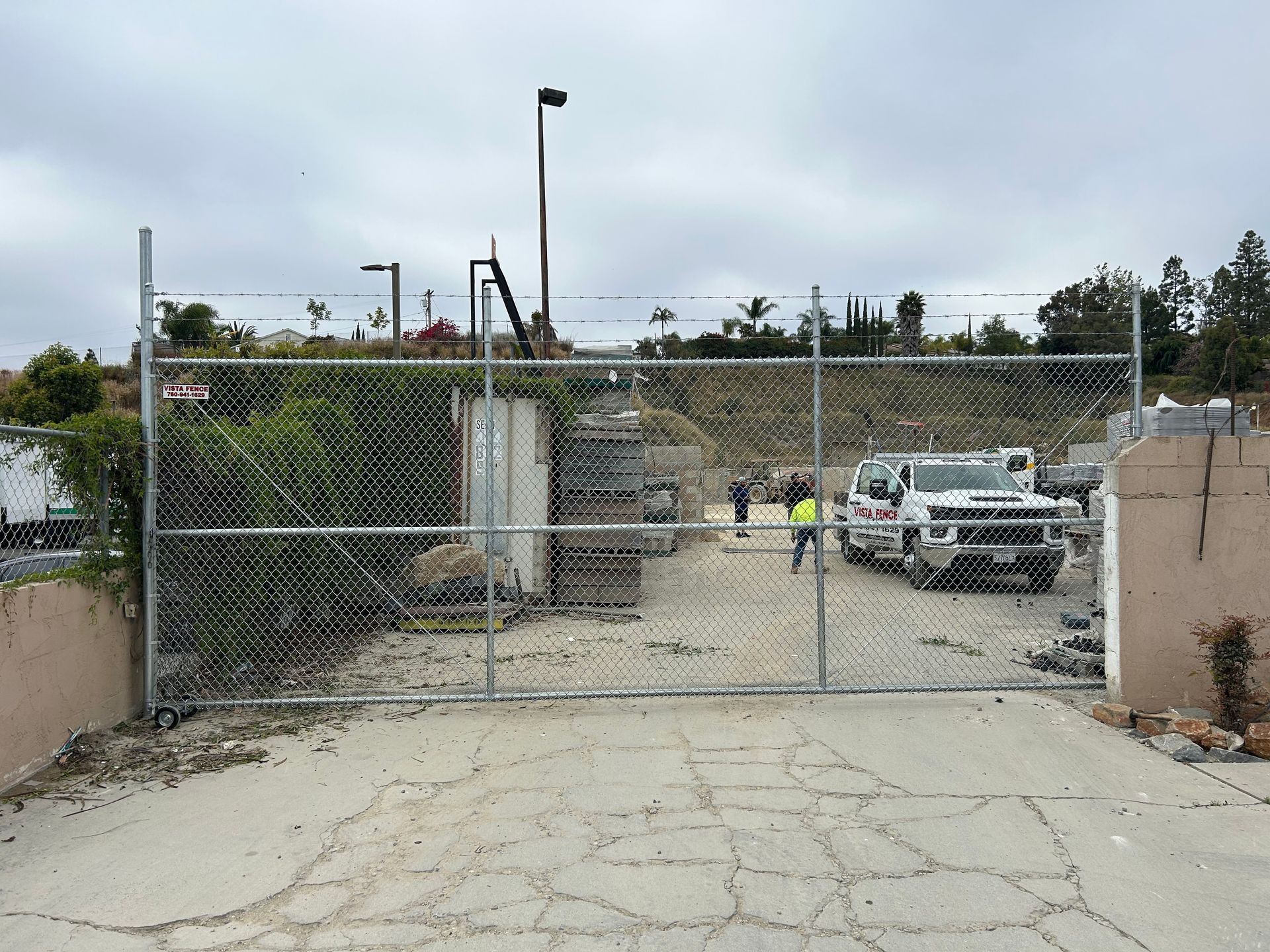 A chain link fence is blocking the entrance to a parking lot.