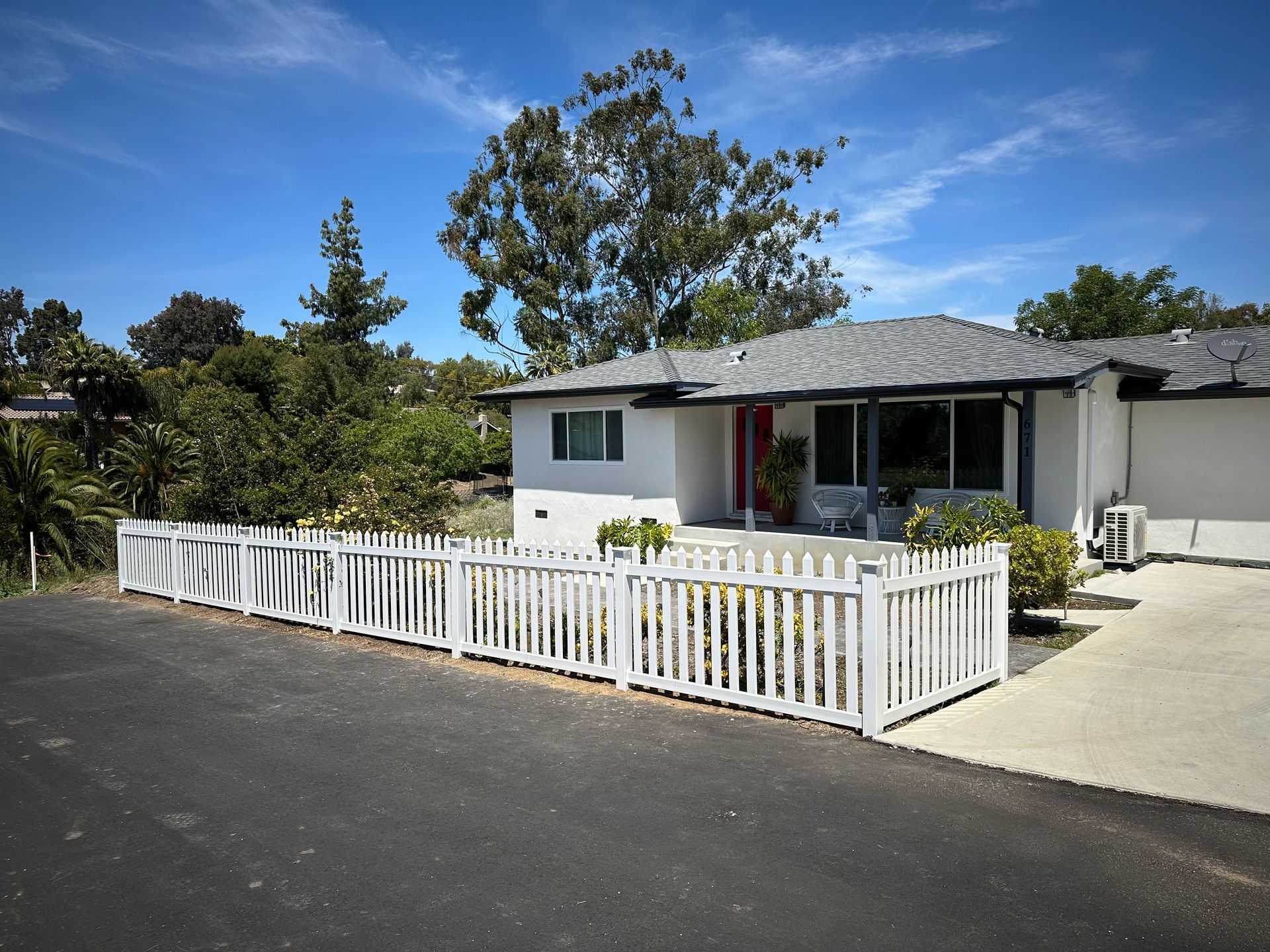 A white house with a white picket fence around it.