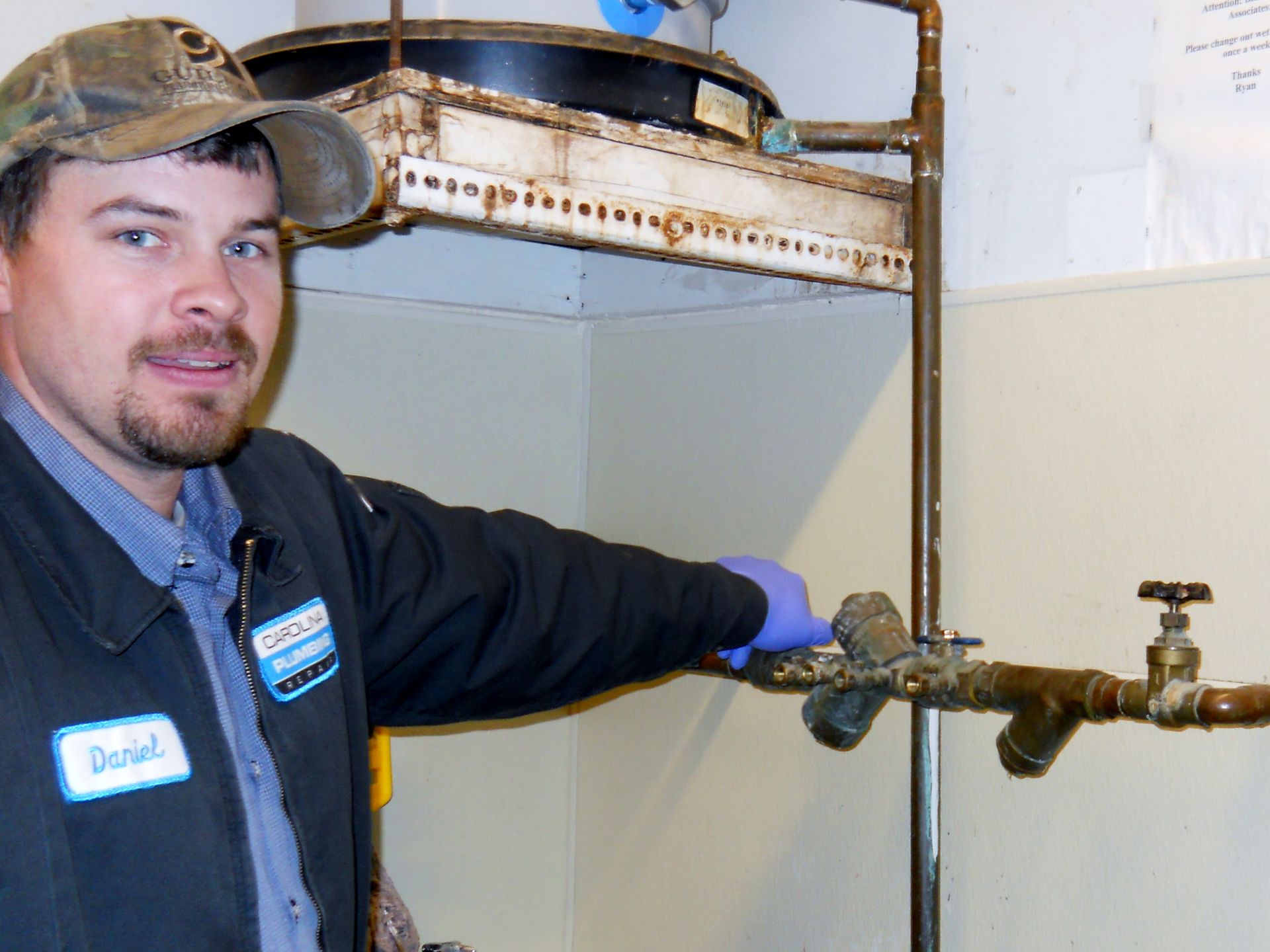 A man wearing a name tag that says john is working on a pipe