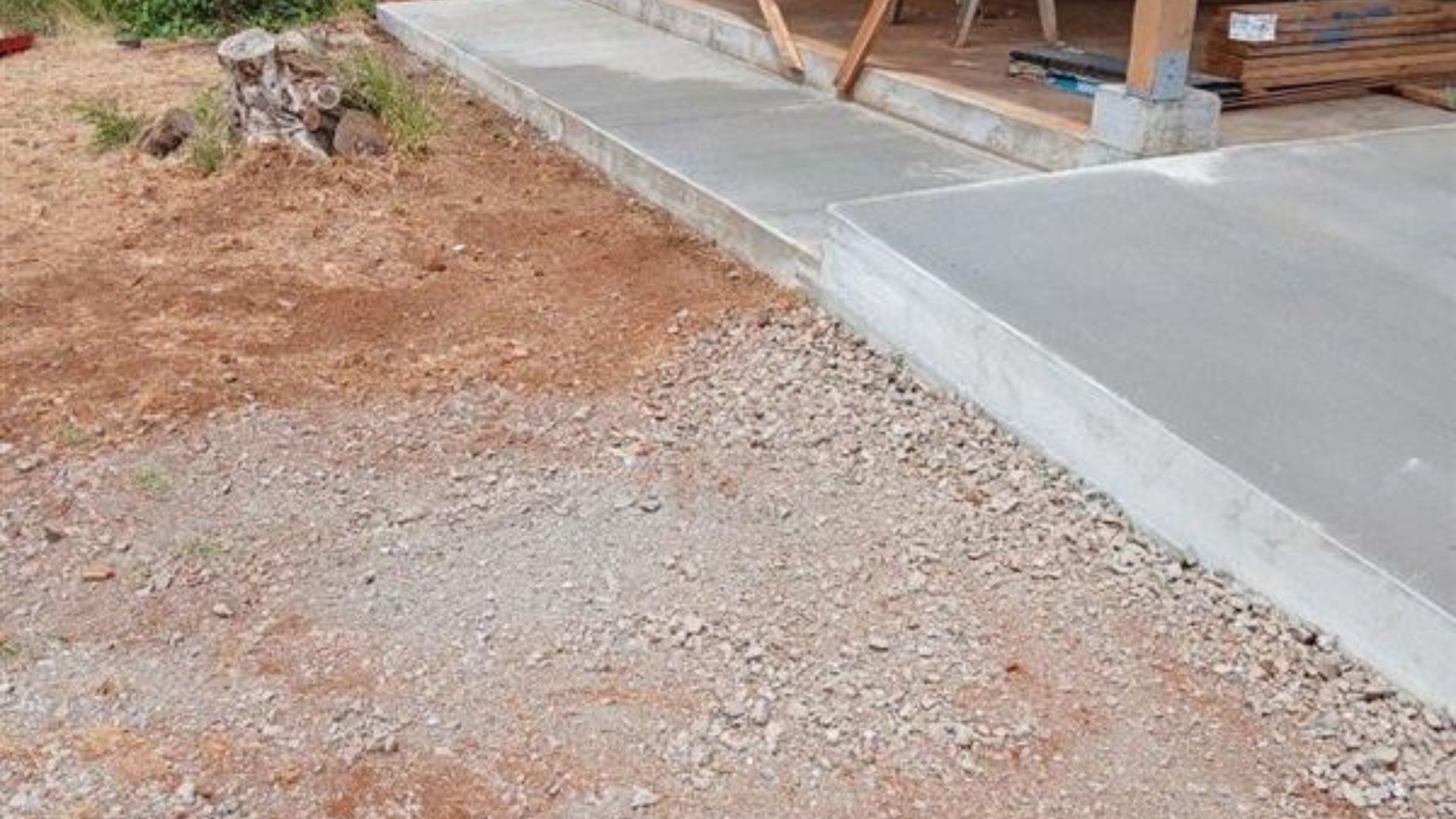 Concrete slab beside a gravel and dirt area at a construction site